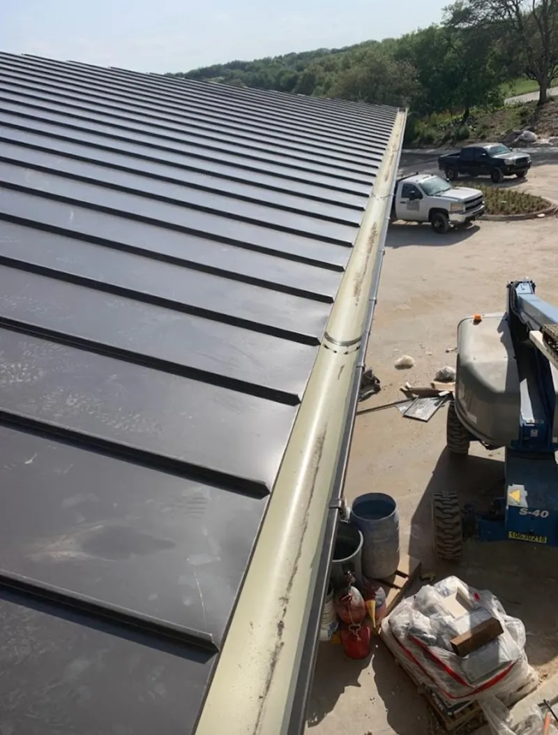 Standing seam panel and gutter detail on a metal roofing jobsite in Marlton
